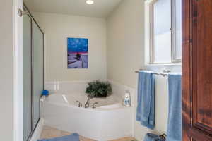 Full bath with tile patterned flooring, a bath, and a shower stall