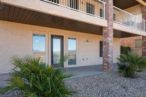 Property entrance with a balcony and stucco siding