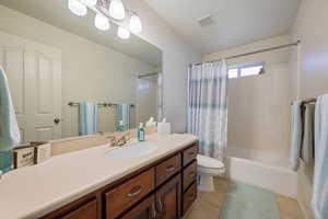 Full bath with shower / bath combination with curtain, visible vents, vanity, and tile patterned floors