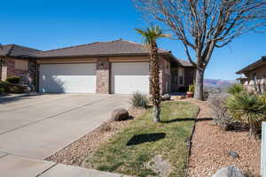 View of property exterior with a garage, driveway, and brick siding