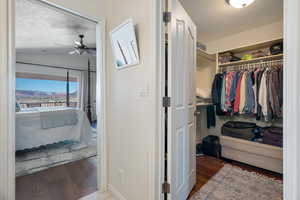 Walk in closet with lofted ceiling, ceiling fan, and wood finished floors