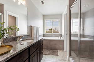 Full bath with a stall shower, visible vents, tile patterned floors, a garden tub, and a sink