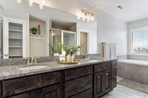 Bathroom with a shower stall, visible vents, a sink, and tile patterned floors