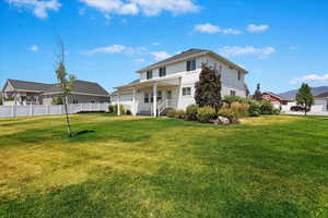 View of front facade featuring fence, board and batten siding, and a front yard