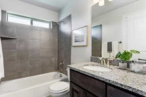 Bathroom featuring shower / bathtub combination, vanity, and toilet