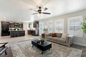 Living area with light tile patterned floors, ceiling fan, baseboards, and recessed lighting