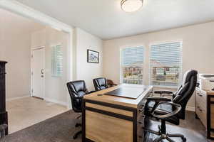 Office featuring light carpet, light tile patterned floors, and baseboards