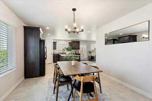 Dining room featuring a chandelier, recessed lighting, light tile patterned flooring, and baseboards