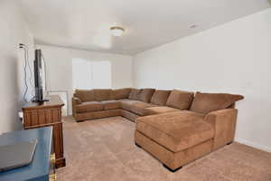 Living area featuring baseboards, visible vents, and light colored carpet