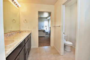 Ensuite bathroom with toilet, a sink, ensuite bath, and double vanity