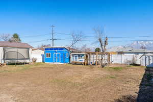 Backyard featuring an storage shed/workshop, a mountain view, a chicken coop, and a trampoline