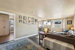 Living area with a healthy amount of sunlight, and wood finished floors