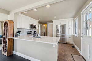 Kitchen with a peninsula, a healthy amount of sunlight, and stainless steel appliances