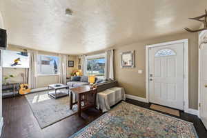 Entryway featuring a textured ceiling, and dark wood-style flooring