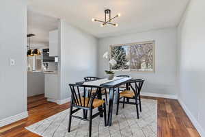 Dining room featuring light wood-style floors, baseboards, and a chandelier