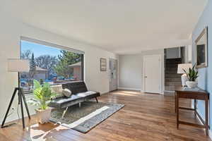 Living area with visible vents, stairs, baseboards, and wood finished floors