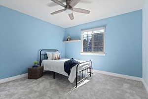 Bedroom with ceiling fan, carpet floors, and baseboards