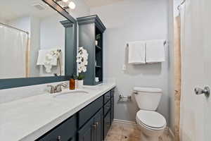 Full bathroom with visible vents, toilet, vanity, tile patterned flooring, and baseboards