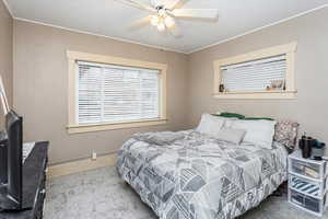 Bedroom featuring carpet floors, ceiling fan, and ornamental molding