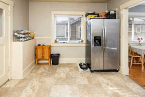 Kitchen with plenty of natural light, baseboards, and stainless steel fridge with ice dispenser