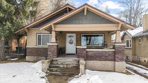 View of front of house with a porch and brick siding