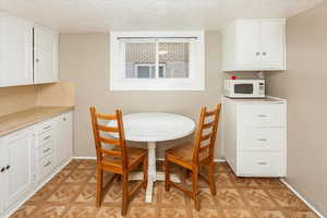 Dining area with a textured ceiling and baseboards