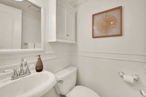 Half bathroom featuring a sink and crown molding