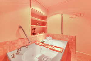 Bathroom with a tub with jets, ornamental molding, tile walls, and tile patterned floors
