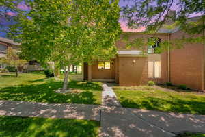 View of front of home with brick siding and a front yard