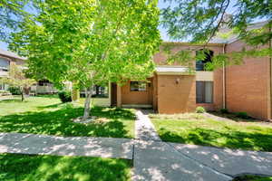 View of front of home featuring brick siding and a front lawn