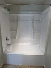 Full bath featuring light tile patterned floors and shower / washtub combination