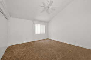 Additional living space featuring carpet floors, ceiling fan, and lofted ceiling