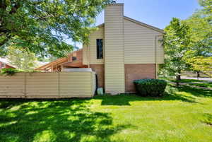 Back of house featuring brick siding and a chimney