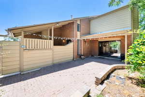 Rear view of property featuring brick siding and a patio