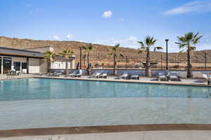 Community pool with fence, a mountain view, and a patio