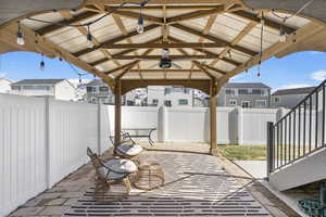 View of patio / terrace with a fenced backyard, a residential view, a ceiling fan, and a gazebo