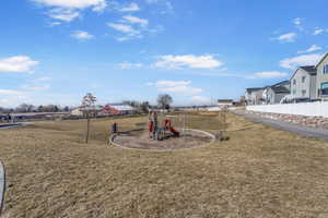 Community playground featuring a residential view, a yard, and fence