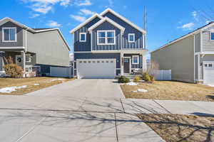 View of front of property with a garage, fence, board and batten siding, and concrete driveway