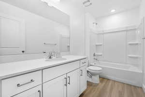 Bathroom featuring bathtub / shower combination, toilet, wood finished floors, vanity, and visible vents