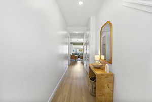 Hallway featuring recessed lighting, baseboards, and wood finished floors