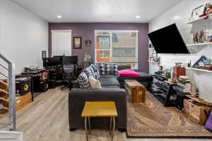 Living area featuring light wood finished floors and recessed lighting