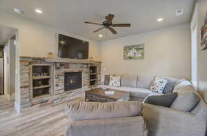 Living room featuring recessed lighting, visible vents, a fireplace, and wood finished floors