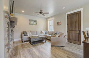 Living area with ceiling fan, baseboards, light wood-style flooring, and recessed lighting