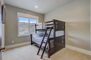 Bedroom with light carpet, baseboards, and recessed lighting