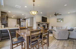 Dining space featuring a fireplace, recessed lighting, visible vents, light wood-style flooring, and ceiling fan