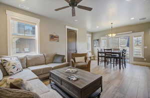 Living area with light wood-style floors, recessed lighting, and visible vents