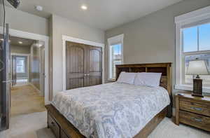 Bedroom featuring baseboards, a closet, recessed lighting, and light colored carpet