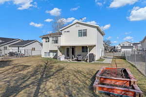 Rear view of property with a patio, a fenced backyard, a garden, a lawn, and a gate