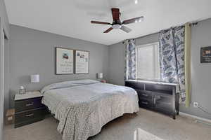 Carpeted bedroom Ceiling fan and big enough for a large bed