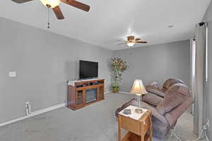 Carpeted living area featuring a ceiling fan, lots of space and walk out